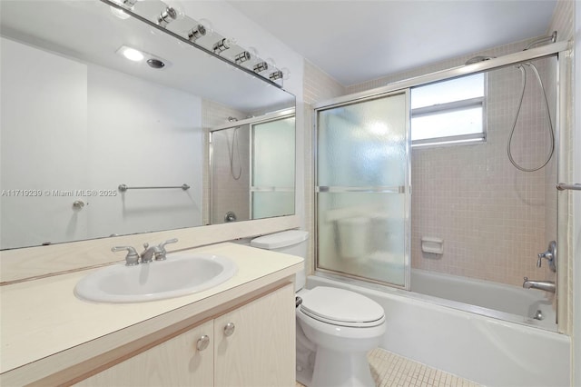 full bathroom featuring tile patterned floors, vanity, toilet, and combined bath / shower with glass door