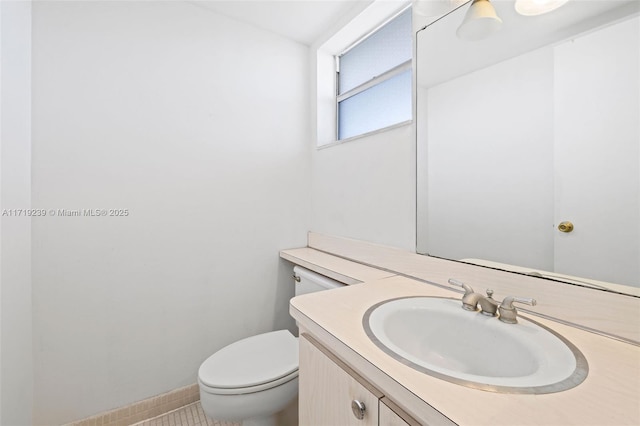 bathroom featuring tile patterned flooring, vanity, and toilet