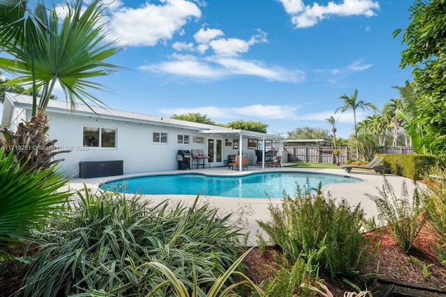 view of swimming pool featuring a grill and a patio