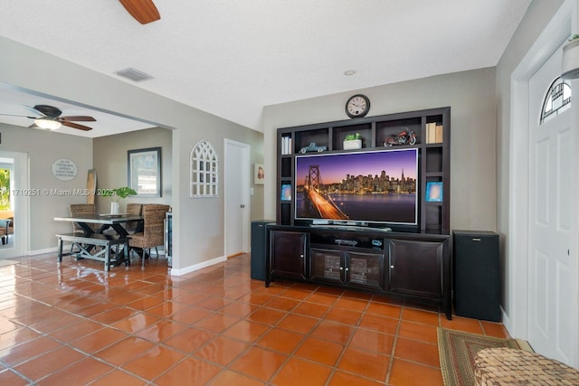 tiled living room with a textured ceiling and ceiling fan