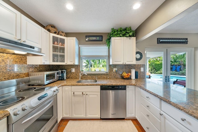 kitchen with appliances with stainless steel finishes, backsplash, white cabinetry, and sink