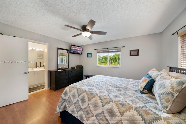 bedroom featuring connected bathroom, ceiling fan, a textured ceiling, and light wood-type flooring