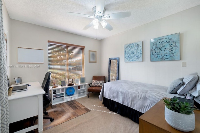 carpeted bedroom with a textured ceiling and ceiling fan