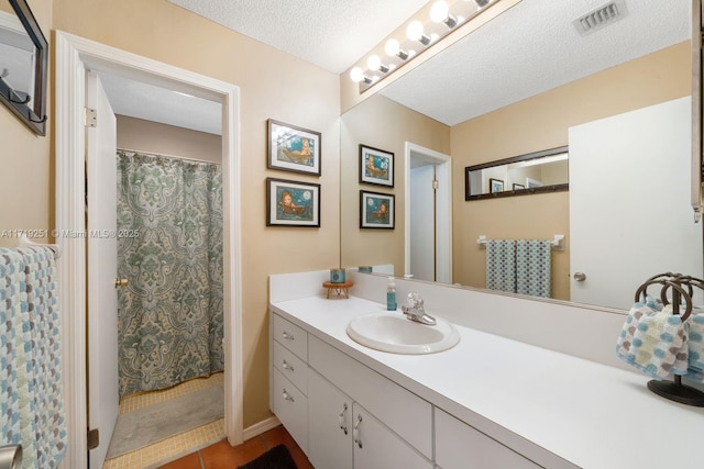 bathroom featuring vanity, a shower with curtain, a textured ceiling, and tile patterned floors