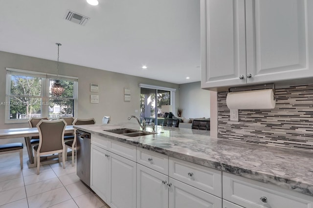 kitchen featuring stainless steel dishwasher, sink, white cabinetry, hanging light fixtures, and light stone countertops