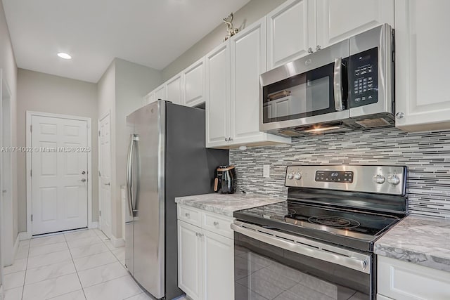 kitchen with white cabinets, backsplash, and appliances with stainless steel finishes