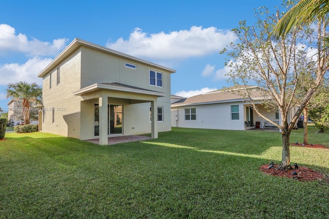 rear view of property featuring a lawn and a patio