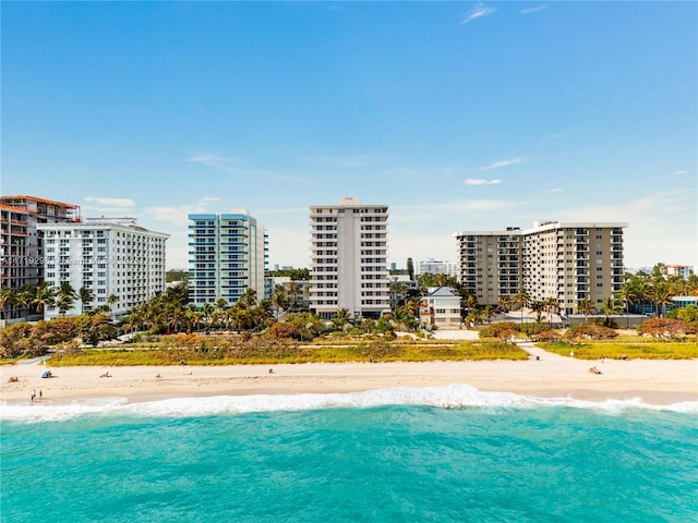 aerial view with a water view, a view of city, and a beach view