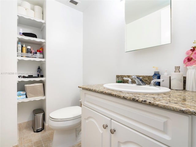 bathroom featuring toilet, vanity, tile patterned flooring, and visible vents