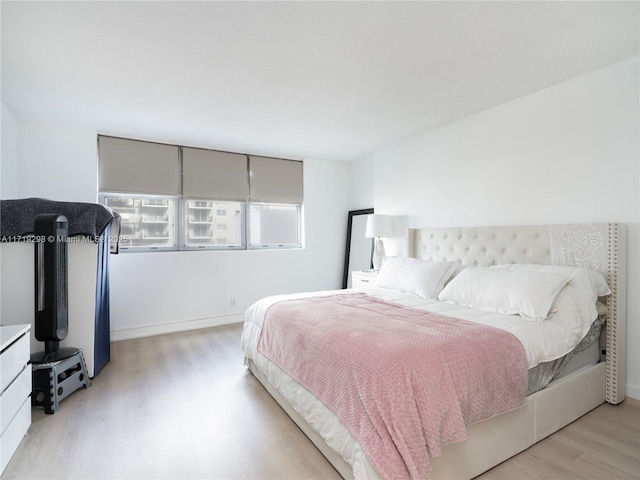 bedroom featuring light wood-style flooring and baseboards