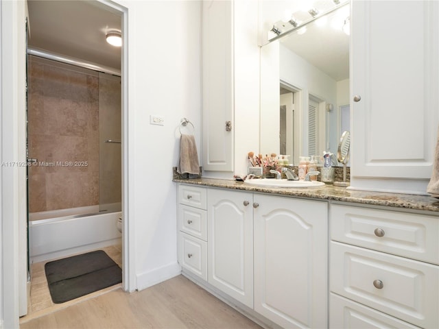 full bathroom featuring vanity, baseboards,  shower combination, toilet, and wood finished floors