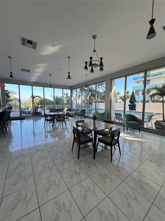 dining room featuring marble finish floor, visible vents, and a wealth of natural light