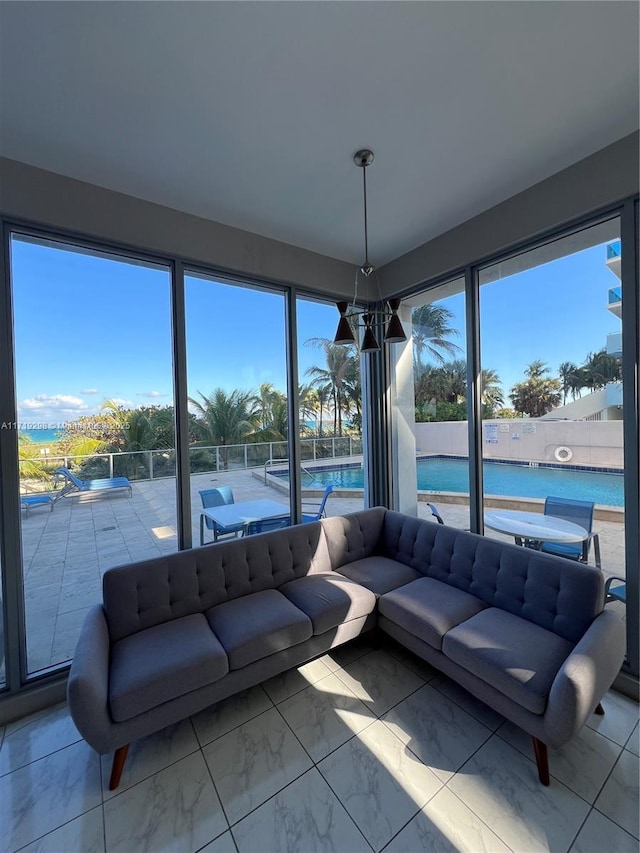 sunroom featuring a water view