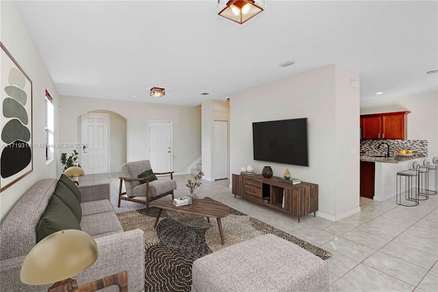 living room featuring light tile patterned floors and sink