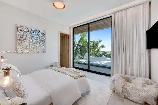 bedroom with access to exterior and light hardwood / wood-style flooring