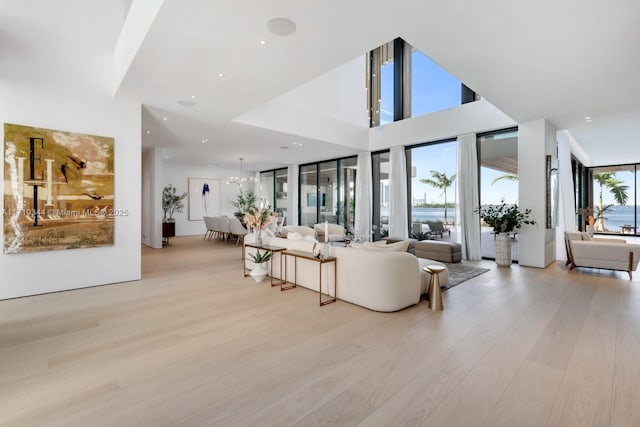 living room featuring a chandelier, light hardwood / wood-style floors, and a water view