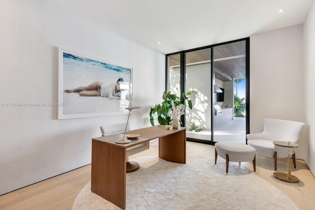 home office featuring floor to ceiling windows and light wood-type flooring