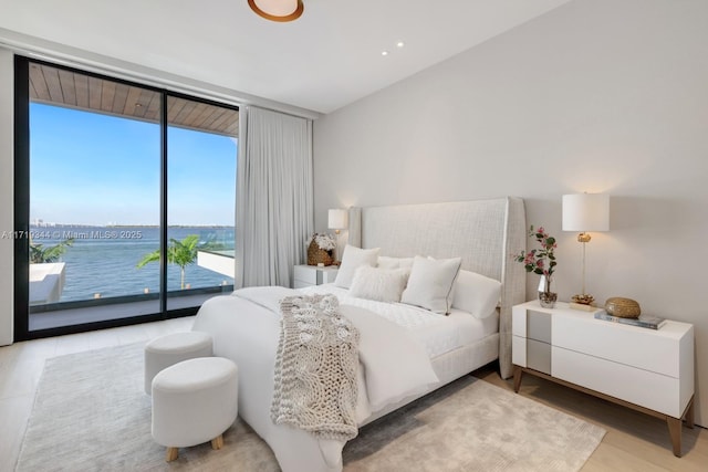 bedroom with access to exterior, floor to ceiling windows, and a water view