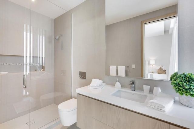 bathroom featuring walk in shower, vanity, tile walls, and toilet