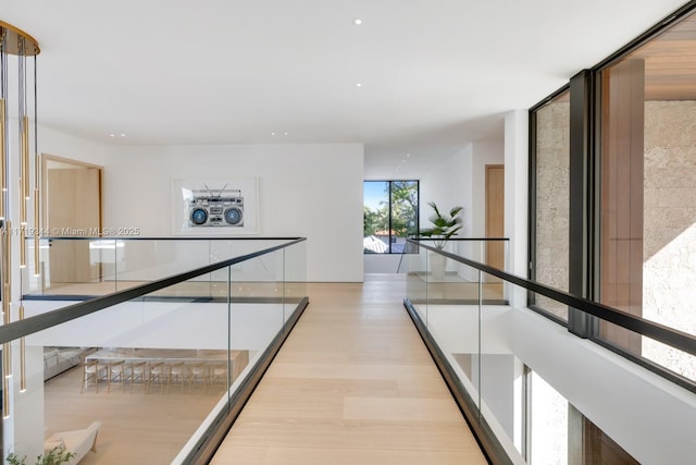 corridor featuring washer / dryer, light hardwood / wood-style flooring, and floor to ceiling windows