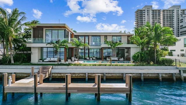 back of property with a water view and an outdoor hangout area