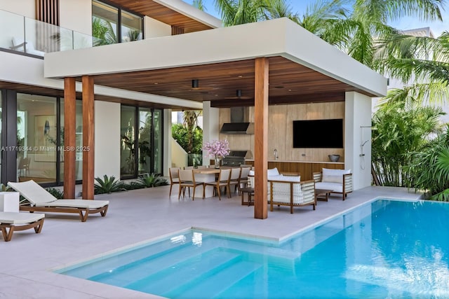 view of pool with outdoor lounge area, a gazebo, exterior kitchen, and a patio