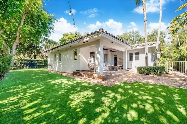 rear view of house with a patio area, ceiling fan, and a lawn