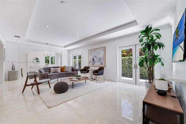 living room featuring french doors and a tray ceiling