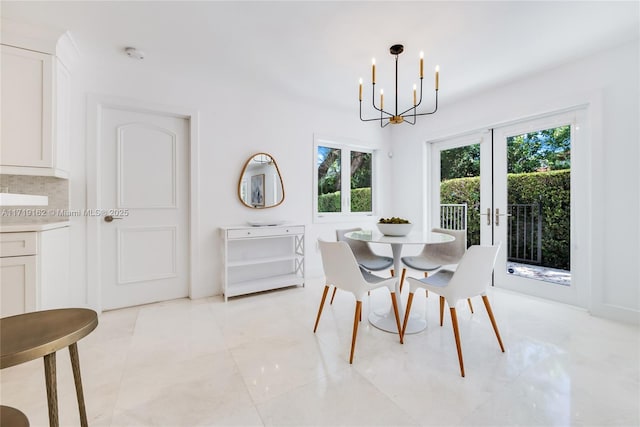 dining space featuring a notable chandelier and french doors