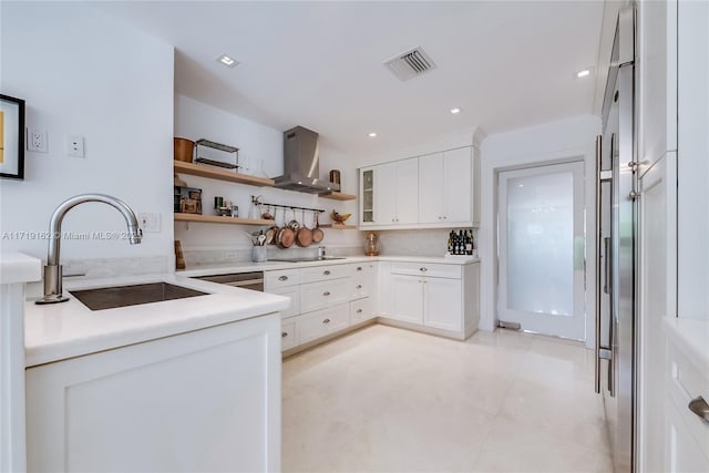 kitchen with wall chimney range hood, sink, stainless steel built in refrigerator, white cabinets, and black electric cooktop