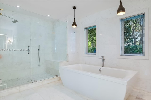 bathroom featuring tile walls and shower with separate bathtub