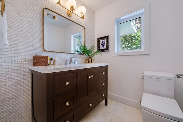 bathroom featuring vanity, brick wall, tile patterned floors, and toilet