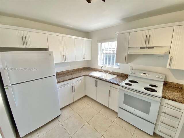 kitchen featuring light tile patterned flooring, light brown cabinets, white appliances, and sink