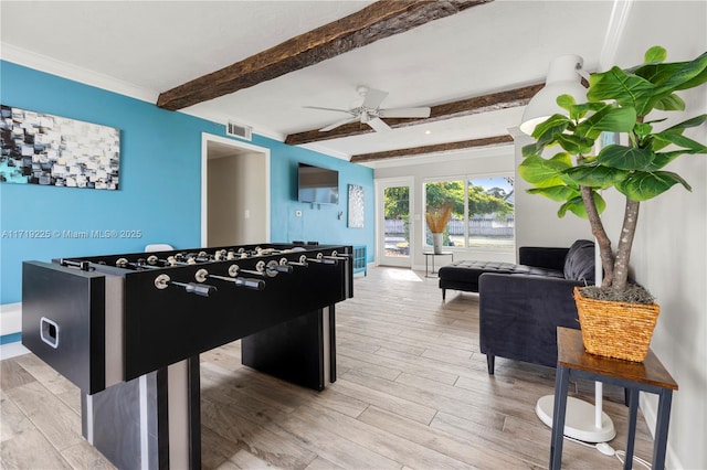 game room featuring beam ceiling, light hardwood / wood-style flooring, ceiling fan, and ornamental molding