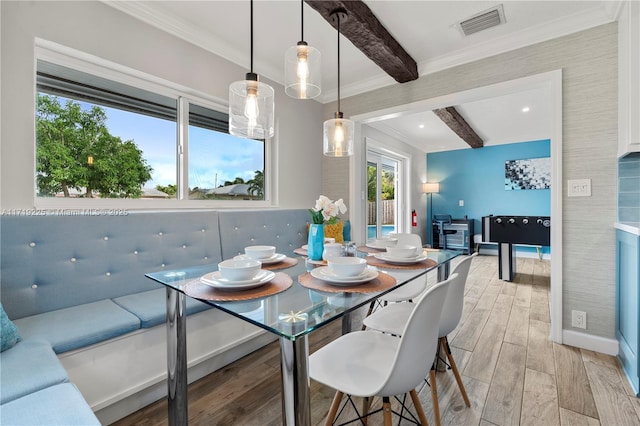 dining area featuring beamed ceiling and ornamental molding