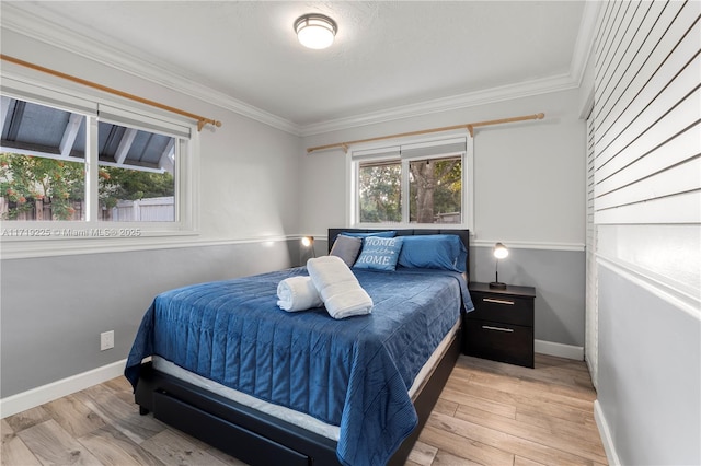 bedroom with light wood-type flooring and crown molding