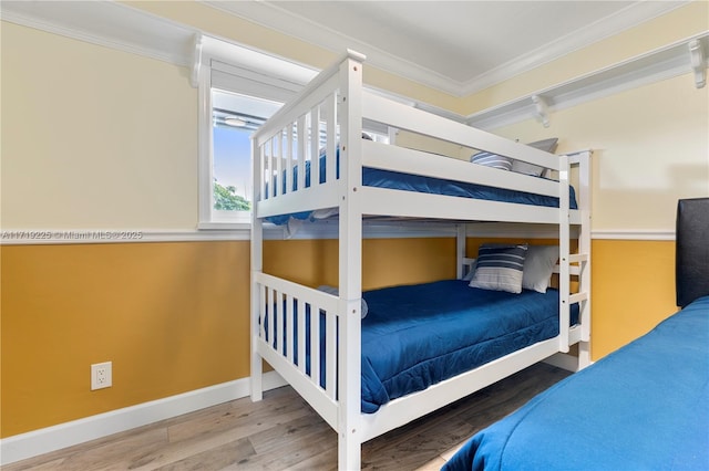 bedroom with wood-type flooring and ornamental molding