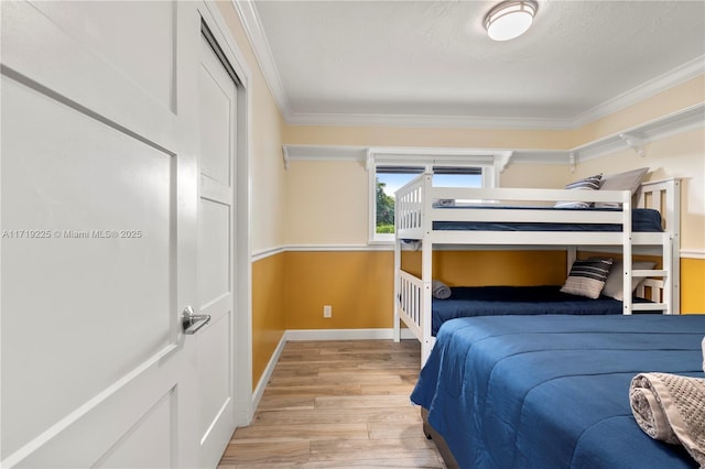 bedroom with light hardwood / wood-style flooring and ornamental molding