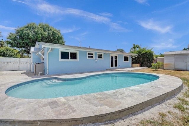 view of pool featuring a patio area and a storage shed