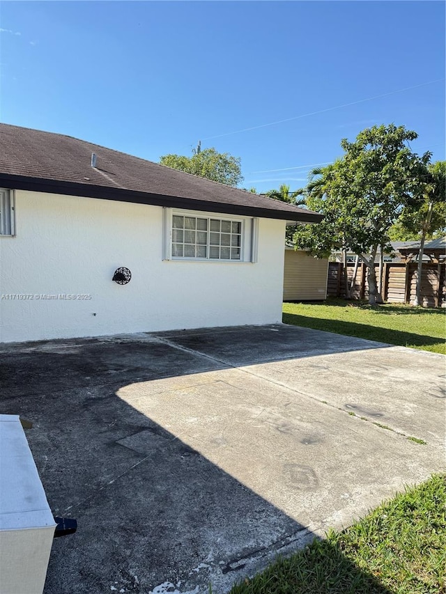 view of side of home with a lawn and a patio area