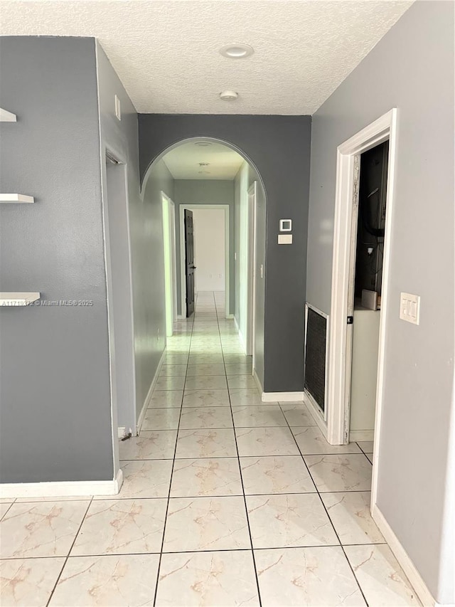 hall featuring a textured ceiling