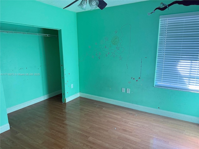 unfurnished bedroom featuring ceiling fan, light hardwood / wood-style floors, and a closet