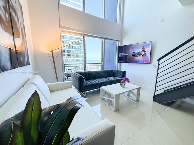 living room featuring light tile patterned floors and a high ceiling