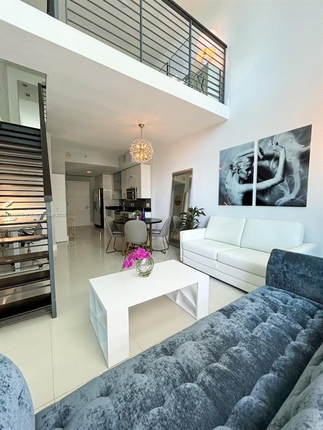 tiled living room featuring a notable chandelier and a high ceiling