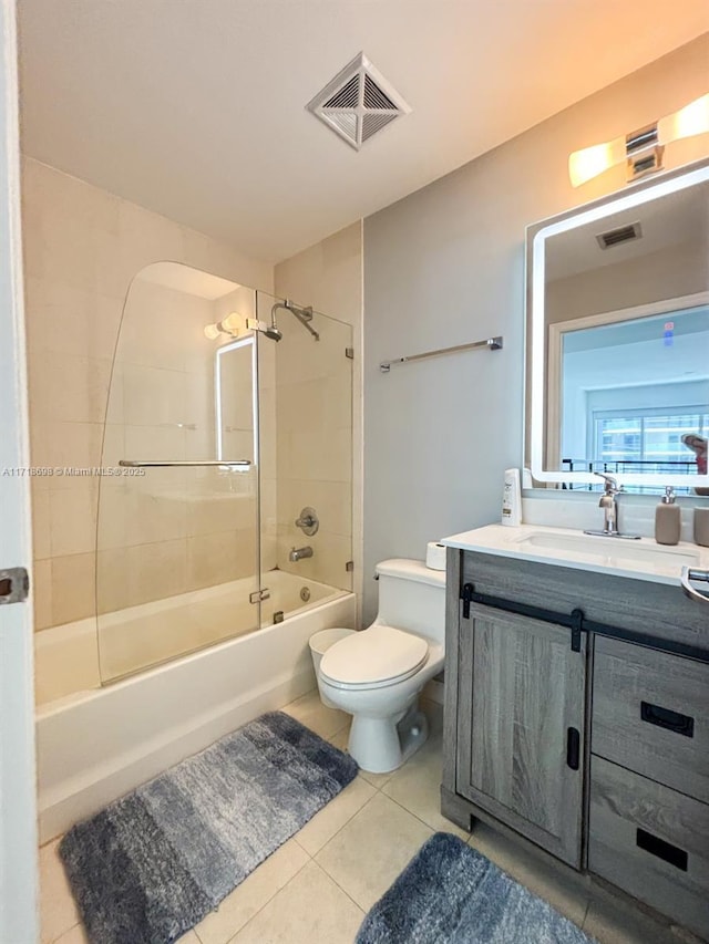 full bathroom featuring tile patterned floors, vanity, toilet, and tiled shower / bath