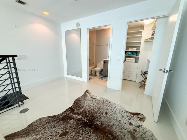 bedroom with a walk in closet and ensuite bathroom