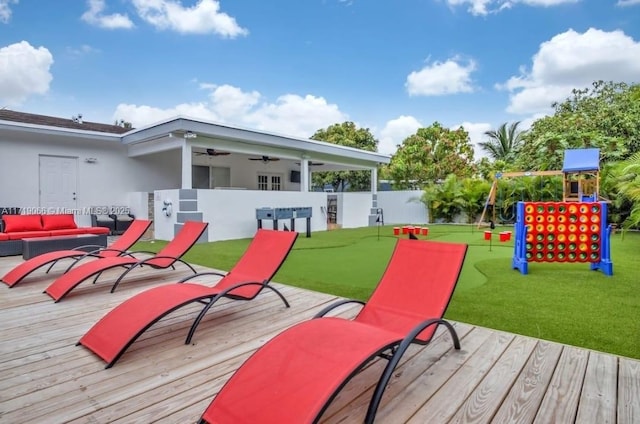 deck featuring a playground, an outdoor living space, and ceiling fan