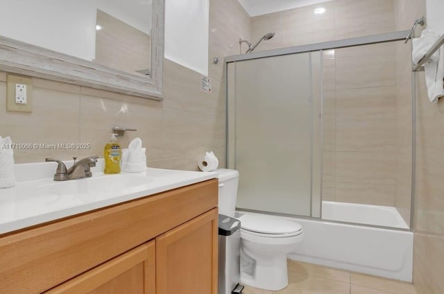 full bathroom with tasteful backsplash, toilet, shower / bath combination with glass door, vanity, and tile walls