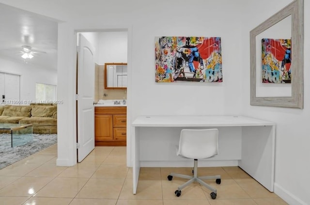 tiled home office featuring ceiling fan and built in desk