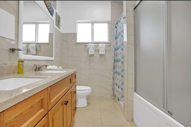 full bathroom featuring tile patterned floors, plenty of natural light, toilet, and tile walls